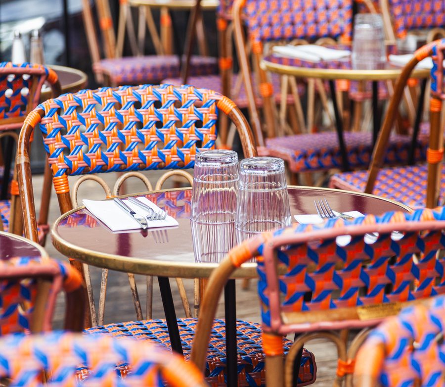 The terrace at Les Pipelettes du Boulevard, laid tables under the awnings